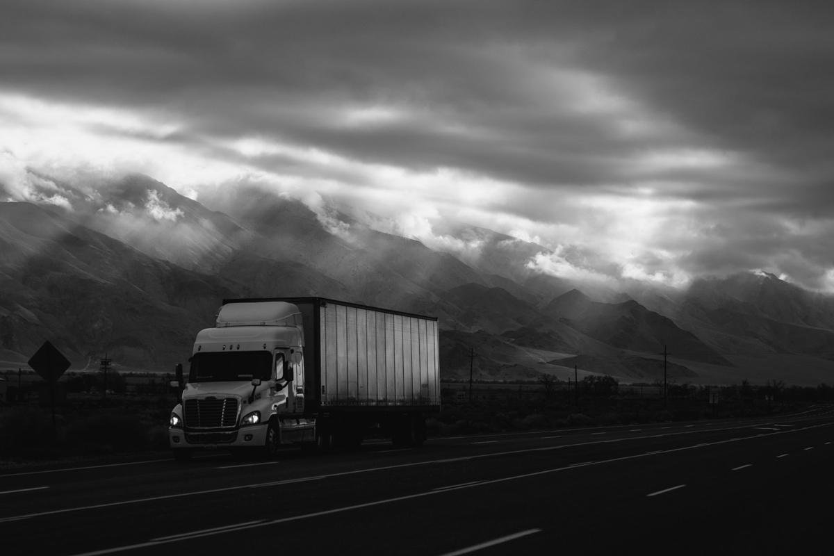 Truck and trailer on a mountain highway in black and white