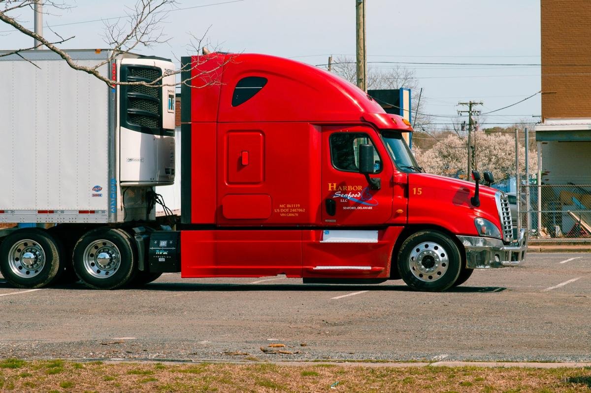 Red tractor coupled to a refrigerated trailer with the reefer unit visible